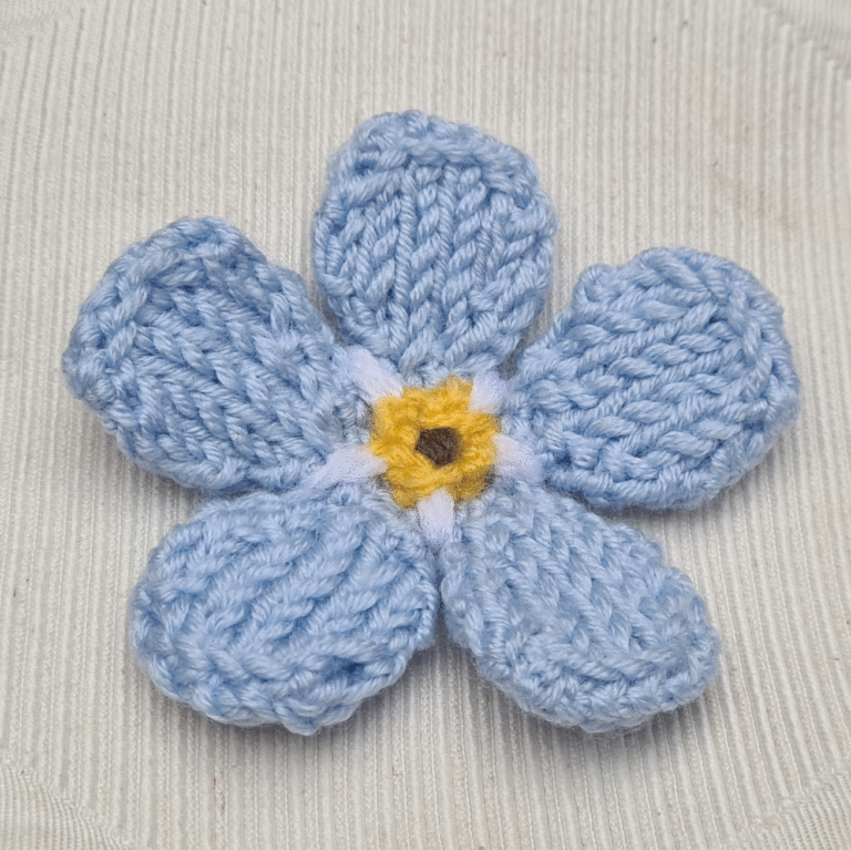 knitted forget me not on white background cushion