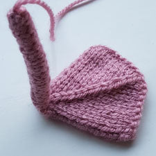 Knitted swan feet in pink on a light background