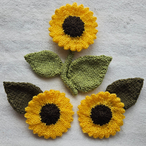 Knitted sunflowers and leaves on a textured gray background