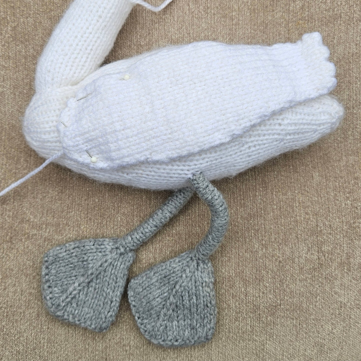 Knitted swan wings on a beige background