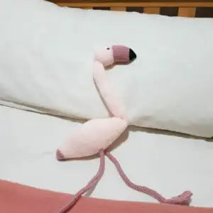 Pink flamingo toy with a black beak on a white surface
