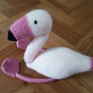 Knitted flamingo toy on a wooden floor