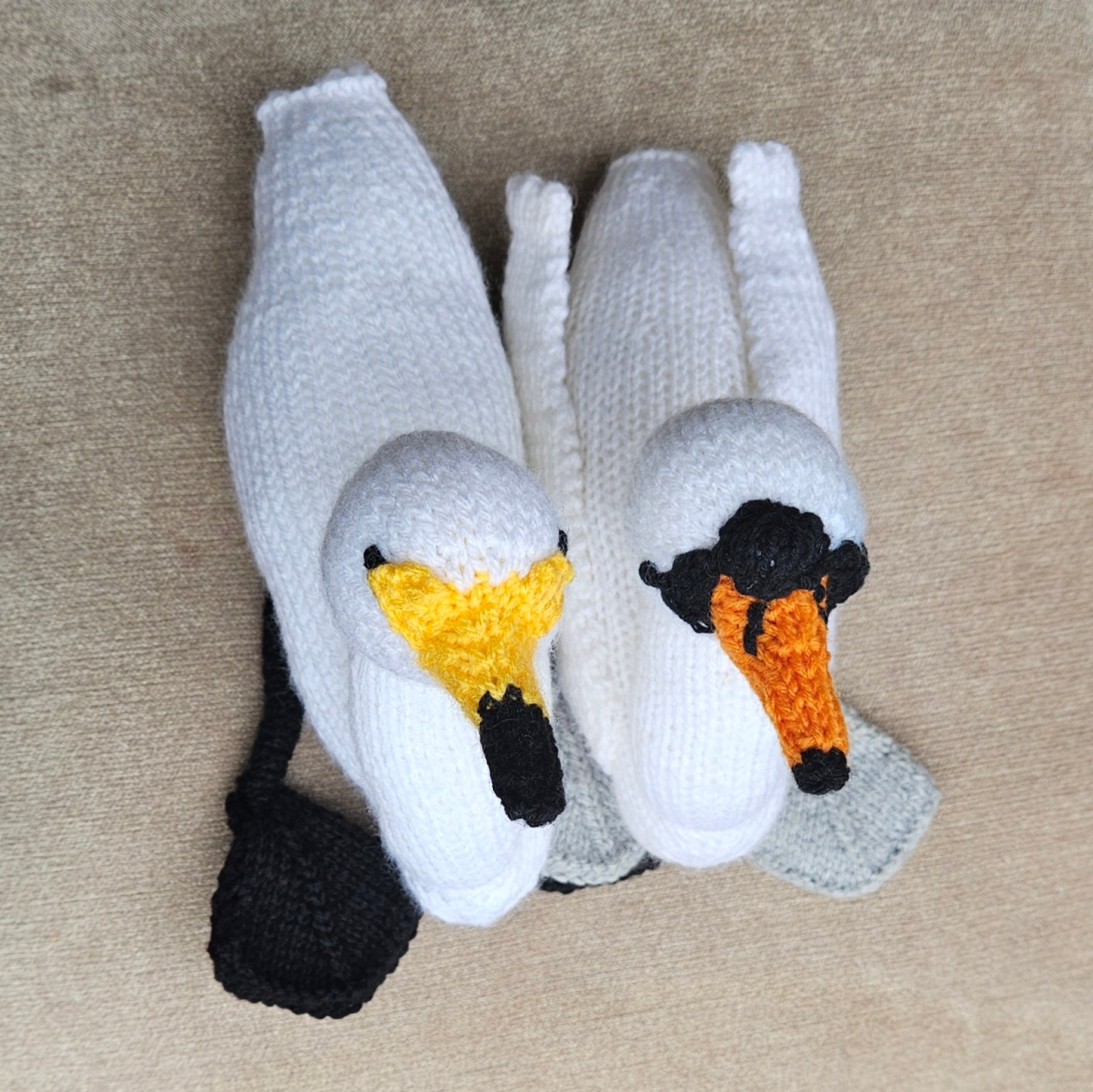 Knitted swan toys on a beige carpet