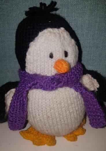 Handmade children fitting in knitting penguin creation